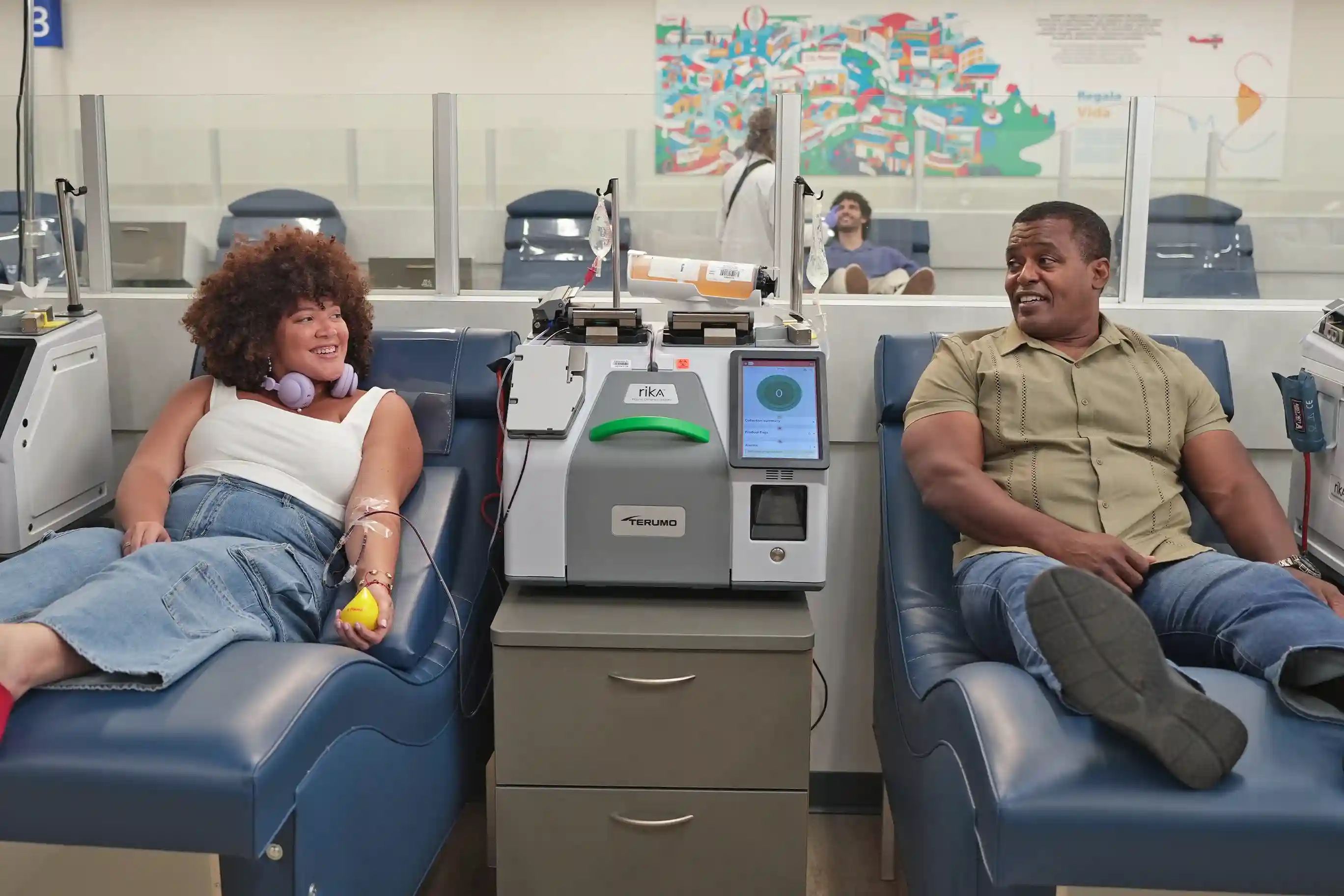 Una mujer y un hombre conversan mientras donan plasma.